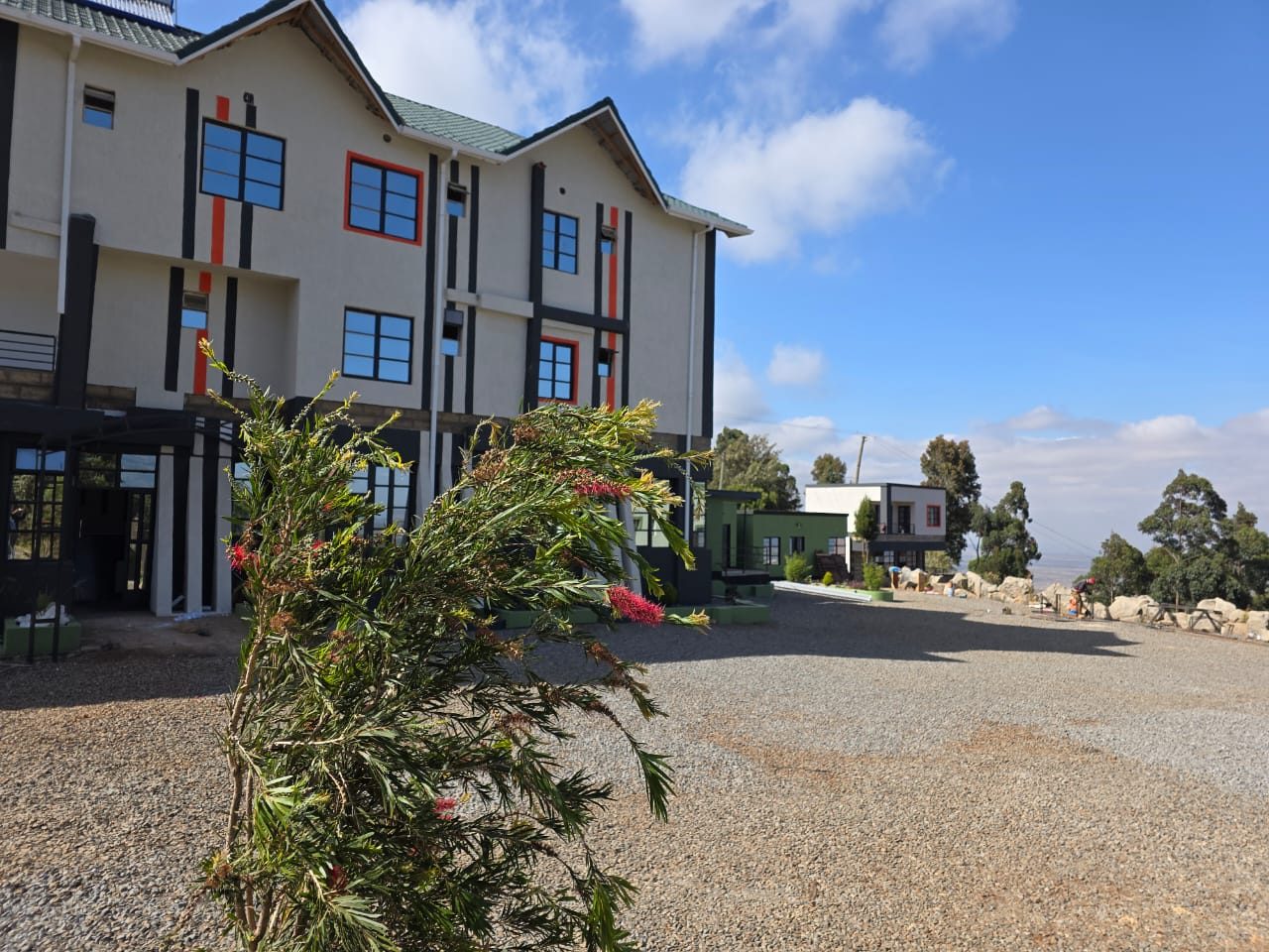 The main accommodation block and gravel forecourt, with the valley beyond.